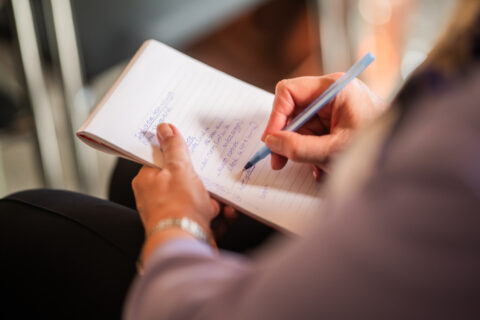 Schrijvende hand maakt aantekeningen op notitieblok