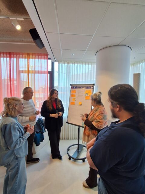 ruimte met mensen voor een bord met "geeltjes"