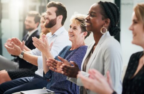 mensen in een bijeenkomst klappen terwijl zij naar de spreker luisteren