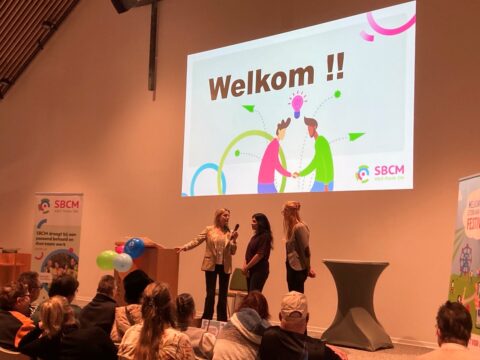 Afbeelding van aanwezigen die in de zaal zitten bij de opening van het Sterk aan het Werk festival