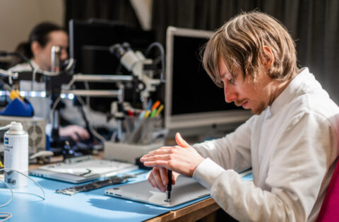 Werknemer is bezig met de reparatie van een laptop